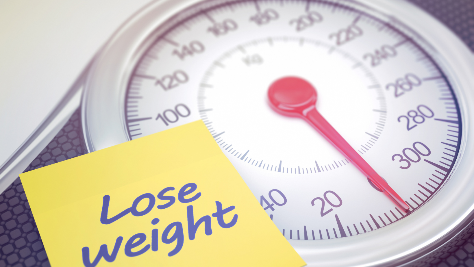 A note reading "lose WEight' sits on a scale. Are fad diets healthy? AHW explores that topic in this blog.