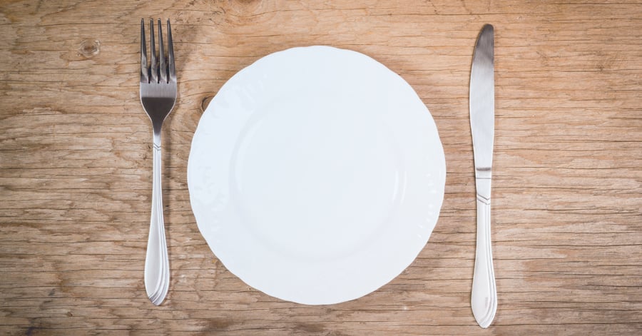 An empty plate between a fork and knife suggest hunger.