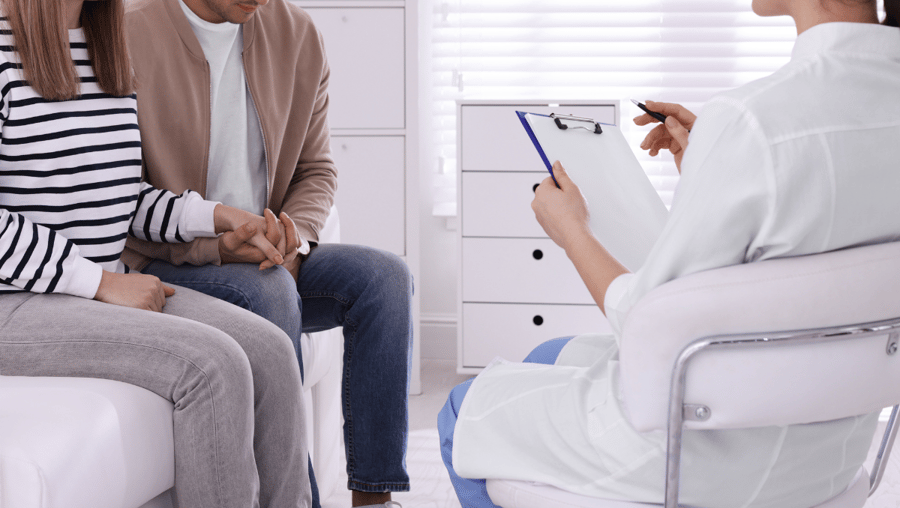 A doctor meets with two patients.