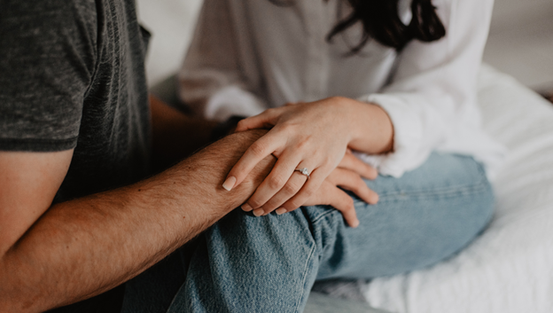 A couple considering vasectomy surgery holds hands. AHW Endowment discusses the science behind vasectomy surgery.
