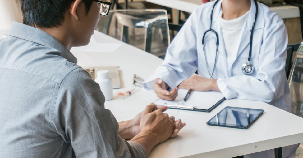 A clinical trial researcher meets with a patient.